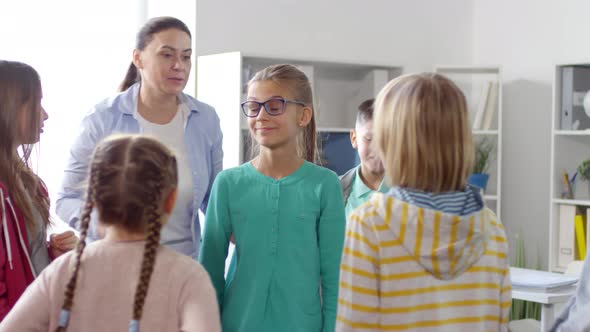 Childcare Tutor Playing Trust Game with Six Kids alt
