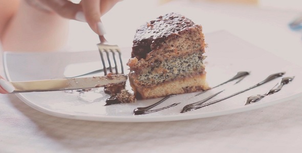 Woman Eating Cake In Restaurant