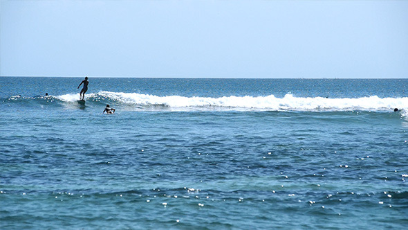 Surfers in Small Waves in Bright Ocean