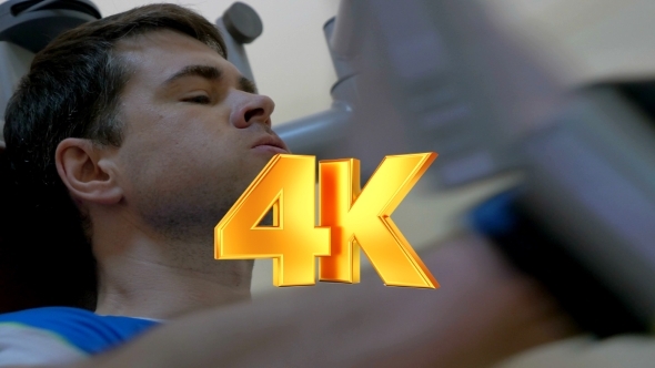 Young Man Doing Exercise On Chest Press Machine alt