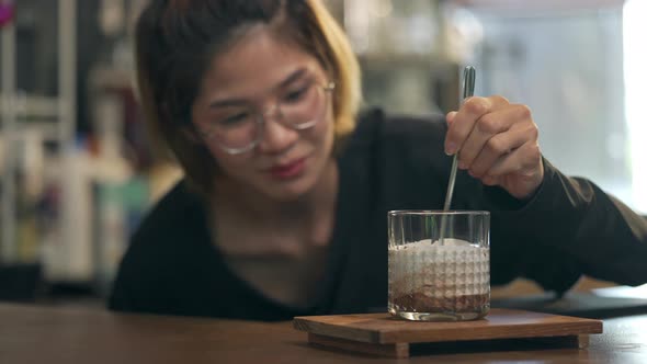 4K Asian woman barista make iced chocolate with froth milk serving to customer