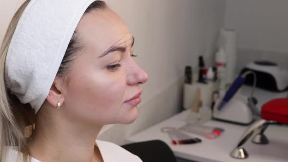 The Hand of a Makeup Artist in Black Gloves Applies a Yellow Eyebrow Paste to the Eyebrow