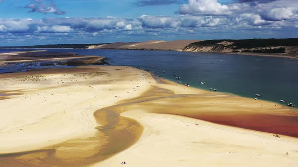 The Banc d'Arguin at Arcachon Bay France with Pilat Dune and boats in the background, Aerial dolly l