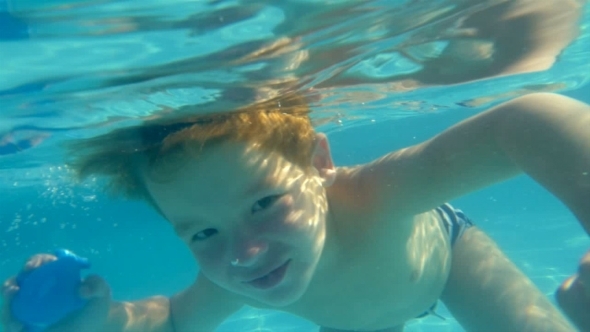 Boy Swimming Underwater In Swimming Pool
