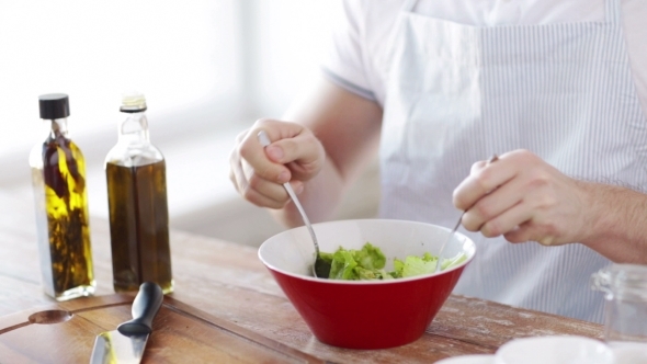 Close Of Male Hands Mixing Salad In Bowl alt