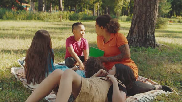 Schoolboy Answering to Young Charming Teacher During Outdoor Lesson