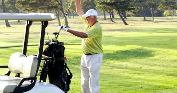 Male golfer putting golf club in golf bag