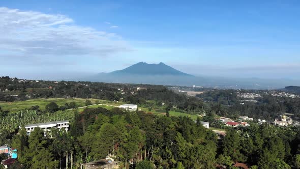 Cinematic aerial view of suburban area with a beautiful mountain in the back and clear blue sky in t