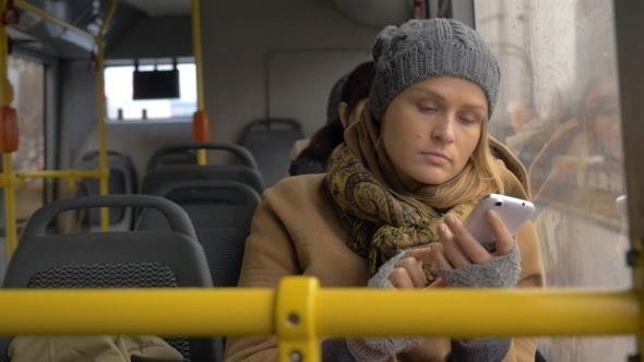 Young Sad Woman Using Smart Phone In The Bus