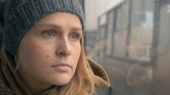 Woman Staring Through The Wet Bus Window alt