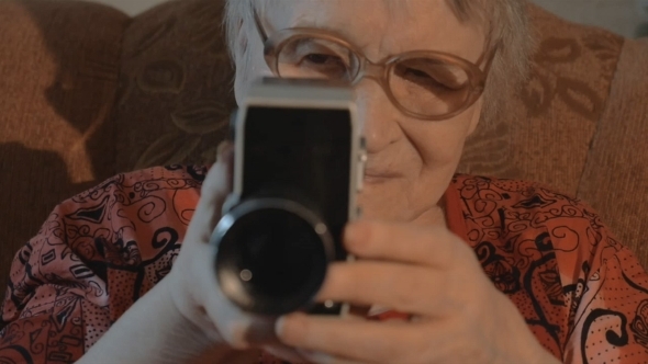 Senior Woman Filming With Retro Video Camera