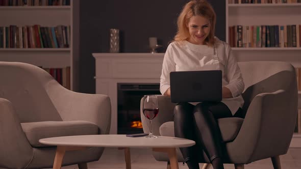 Adult Female Works on Computer in Living Room