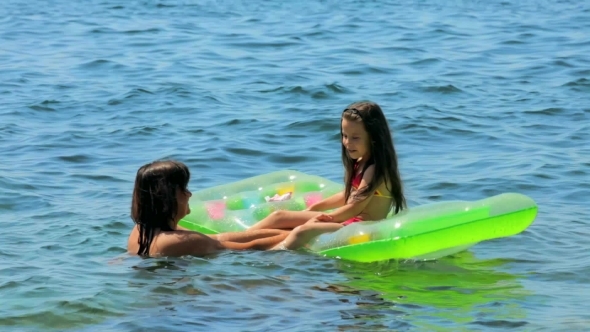 Mom And Daughter Play In The Water Of The Sea.