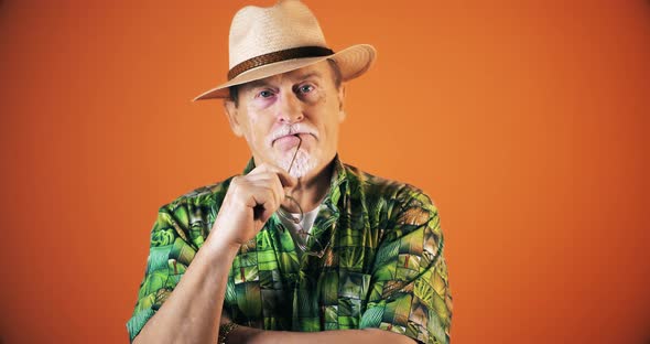 Happy Senior Bearded Tourist Man Looking At Camera Over Orange Wall Background