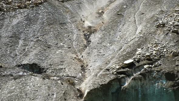 Slow Motion Rockfall in the Mountains Close Up. Lumps of Stones Fall Down From the Melting Glacier