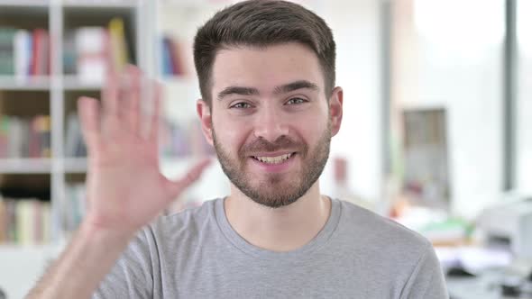 Portrait of Excited Young Man Waving at Camera, 