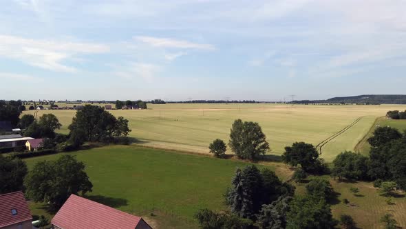 Blue sky, yellow field, green grass.Stunning aerial view flight fly forwards drone footageat Count