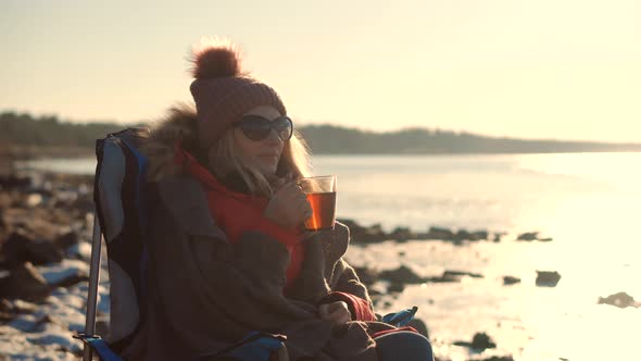 Female Drinking Hot Tea Or Coffee From Mug. Woman Warming Hands Steaming Cup Of Mate Tea.