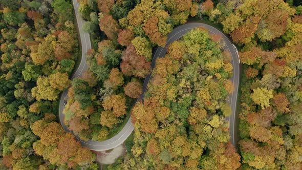 Double, s curve timelapse of fast driving cars, dynamic stabilzed top shot by a drone with the view