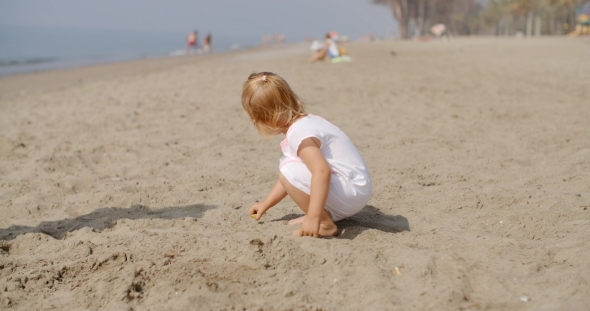 Young Child Playing On Sandy Beach