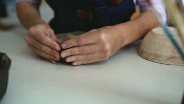 Close up female potter modeling clay bowl in workshop - Artisan work and creative craft concept