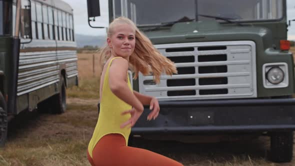 Girl Dancing In Yellow Leotard In Front Of Busses