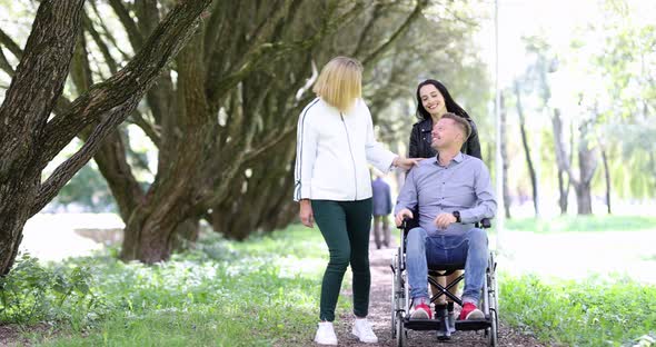 Young Women Walk in the Park and a Man in Wheelchair  Movie