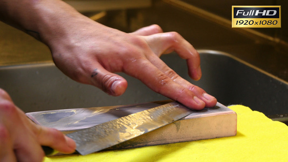 Sushi Chef Sharpening His Knife with a Pink Stone