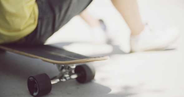 Boy Sitting On a Skateboard Outdoors