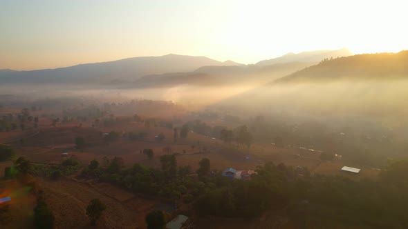 Aerial view from a drone over a misty landscape covers the farmland. 4K