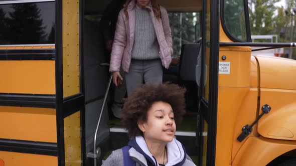Multiethnic Pupils Going Down Steps of School Bus