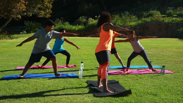 Yoga instructor instructing children in performing exercise