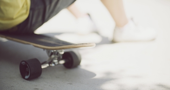 Man Sitting Relaxing On a Skateboard