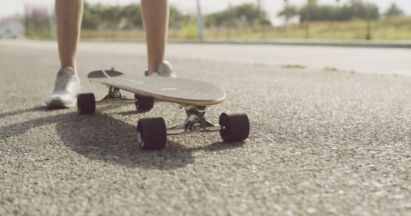 Longboard On The Ground In Front Of a Skater Man