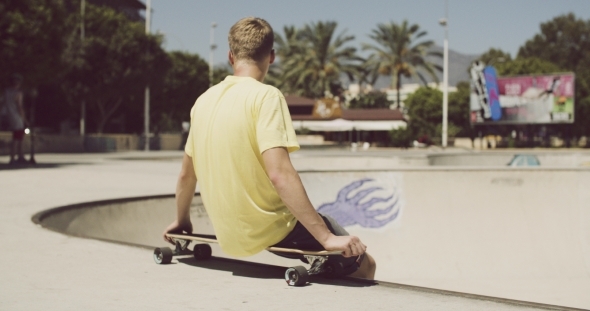 Teenager Is Sitting On His Longboard