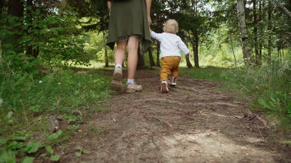 mom and child are walking in the park. shooting concept. open air and payloads for the child