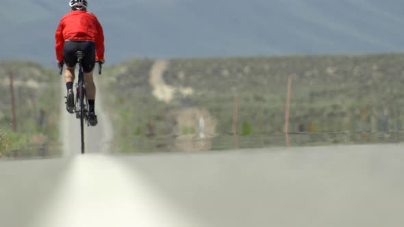 A man road biking on a scenic desert road