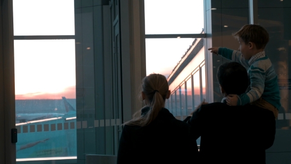 Parents With Son Looking At Planes alt