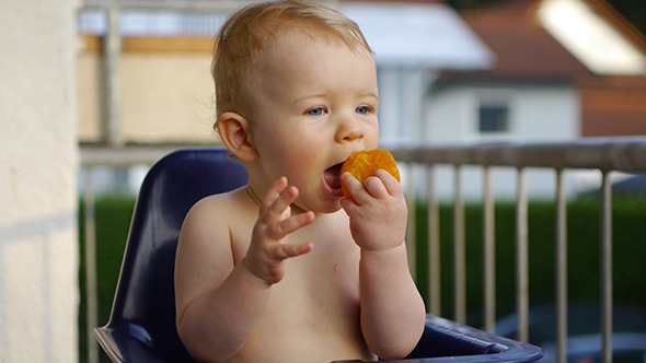 Happy Baby Eating A Peach