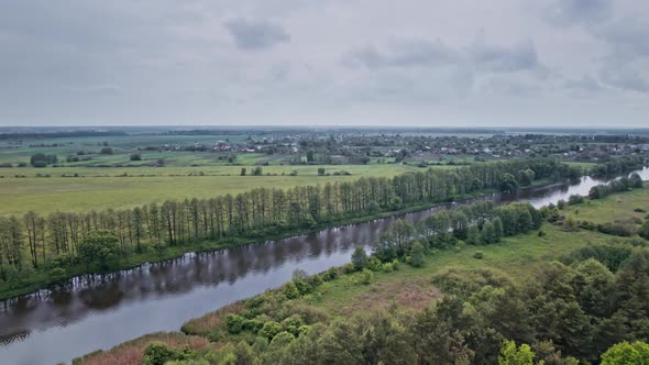 Top View of the River Surrounded By Trees and Meadows