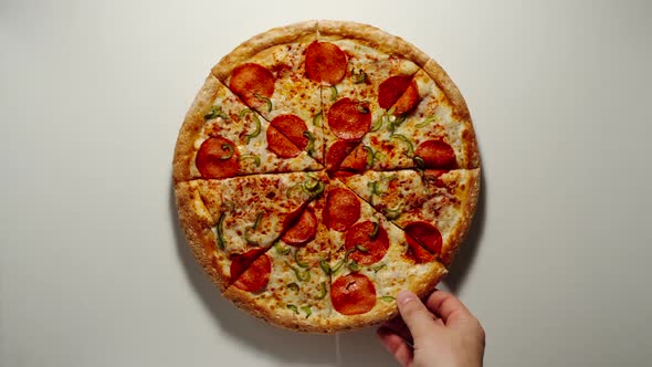 Man Takes A Slice Of Big Pizza From The Wooden Board