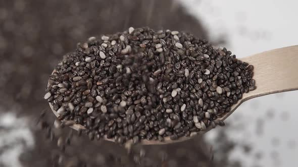 Chia seeds sprinkled into a dessert wooden spoon close up