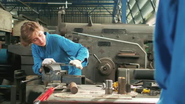 One professional young female worker works in metalwork manufacturing factory.