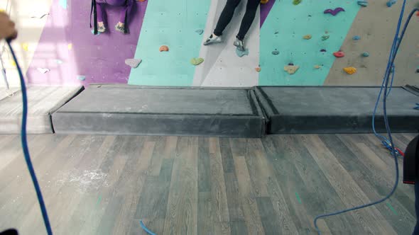 Tilt-up of Woman and Kid Enjoying Indoor Rock-climbing in Modern Gym