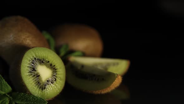 Delicious Juicy Fruit Kiwi and Mint Lie on a Black Table