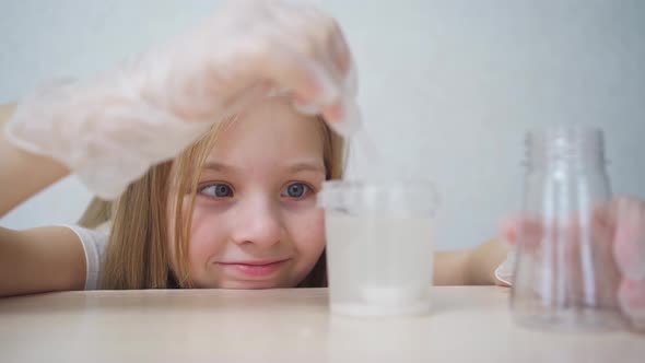 a Cute Little Girl in Protective Gloves Conduct an Experiments at Home