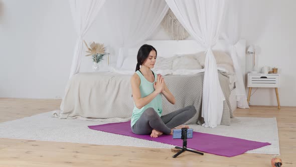 Woman Learning Yoga Online Via Video Conference with Instructor