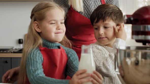 Video of little girl pouring milk into  electric mixer bowl. Shot with RED helium camera in 8K.