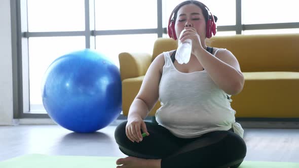 Overweight young woman in sportswear exercising to lose weight at home