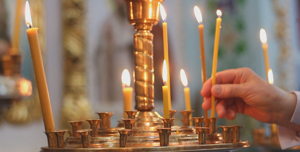 Man Puts a Candle in Church